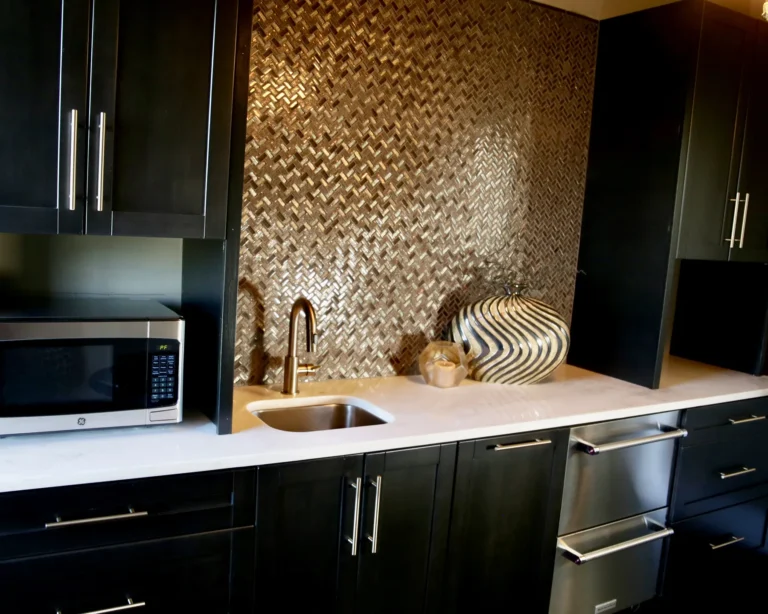 Stumpf black kitchen cabinets and gold backsplash.